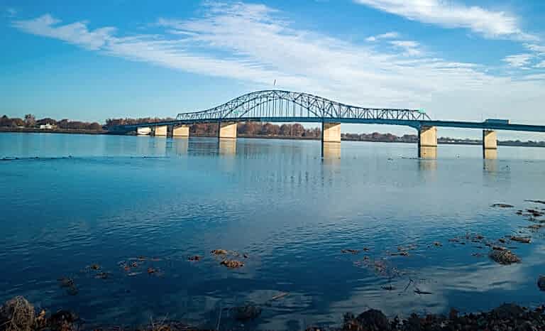 A Curved Bridge Extends Across Calm Waters