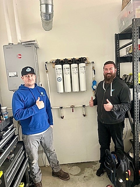 Soft Water Specialists technicians with a newly installed whole-house water filtration system